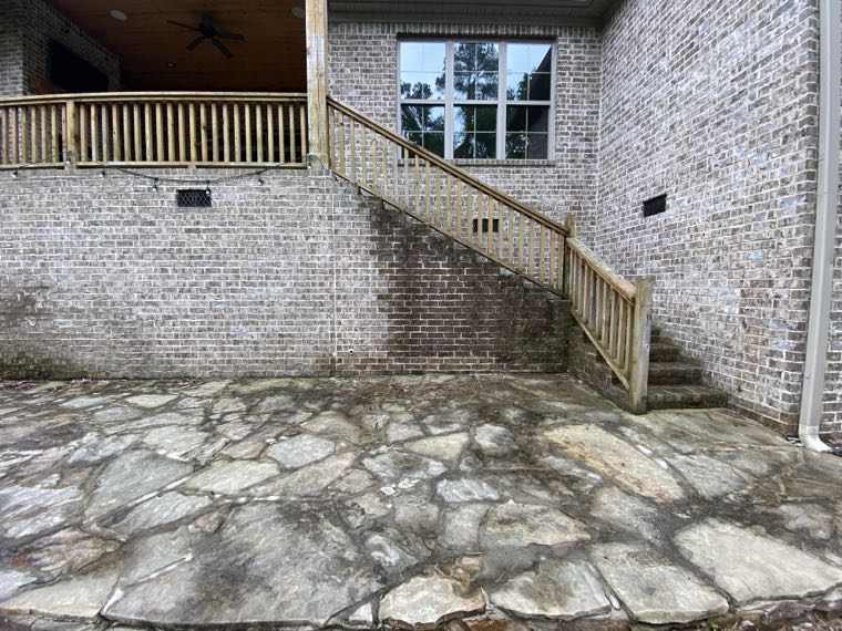 Brick wall and flagstone patio heavily stained before cleaning